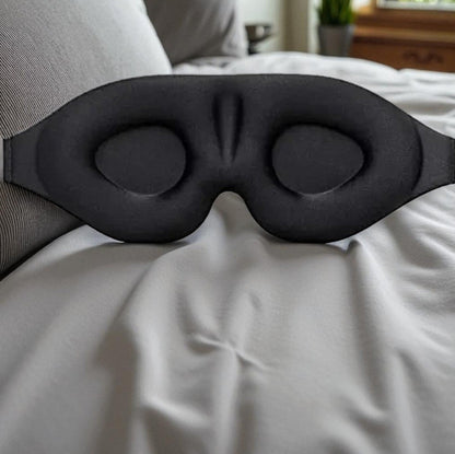 Black sleep mask on a bed in a bedroom setting